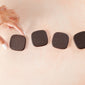 dark chocolate medallions against pink background with hand